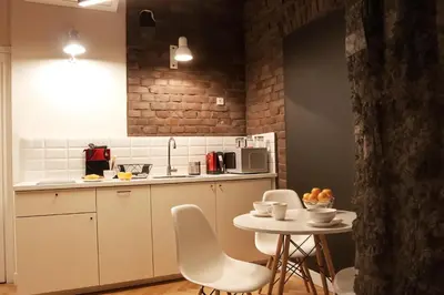 a kitchen with white chairs and a small table at Cracow Fancy Brick #4 - Old Town in Kraków