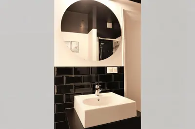 a bathroom with a white sink and a mirror at Cracow Fancy Brick #5 - Old Town in Kraków