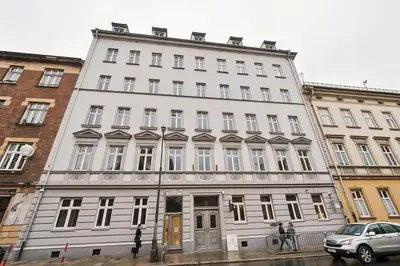 a white building with people standing in front of it at Cracow Fancy Brick #5 - Old Town in Kraków