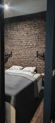 a bed in a room with a brick wall at Cracow Fancy Brick #5 - Old Town in Kraków