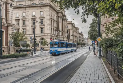 a blue bus driving down a city street at Cracow Fancy Brick #5 - Old Town in Kraków