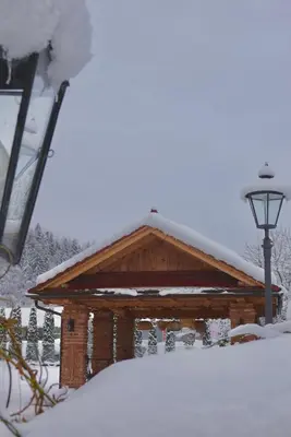 a log cabin with snow on top of it at Gorczańskie Apartamenty Papiernia - Noclegi w górach Gorce in Niedźwiedź