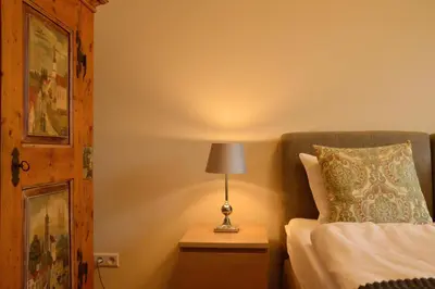 a lamp on a night stand next to a bed at Gorczańskie Apartamenty Papiernia - Noclegi w górach Gorce in Niedźwiedź