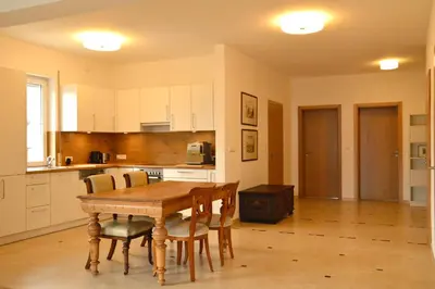 a kitchen with a wooden table and chairs in a room at Gorczańskie Apartamenty Papiernia - Noclegi w górach Gorce in Niedźwiedź
