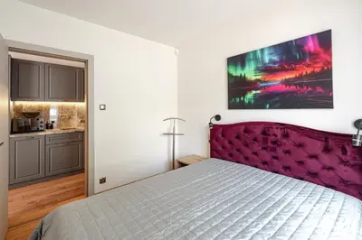 a bedroom with a large bed with a purple headboard at Luna Et Sol Apartments in Rząska