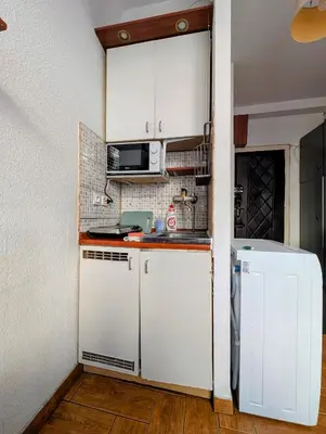 a small kitchen with white cabinets and a refrigerator at Starowiślna 69 by Homeprime in Kraków