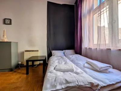 a bedroom with a bed with a window and a table at Starowiślna 69 by Homeprime in Kraków