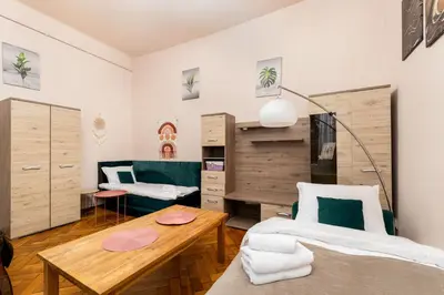 a living room with a bed and a table at Park Strzelecki Cosy Studio by BookingHost in Kraków