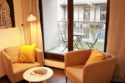 a living room with two chairs and a table at Cracow Copernican Apartment #1 - Old Town in Kraków