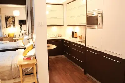 a room with a bed and a kitchen with a table at Cracow Copernican Apartment #1 - Old Town in Kraków