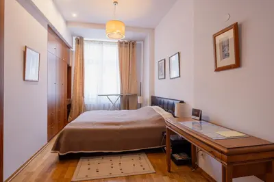 a bedroom with a bed and a desk and a window at One Bedroom city center Krakow in Kraków