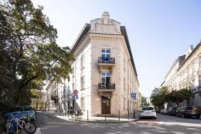 a tall white building on a city street at One Bedroom city center Krakow in Kraków
