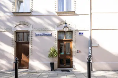 a white building with a door and a potted plant at One Bedroom city center Krakow in Kraków