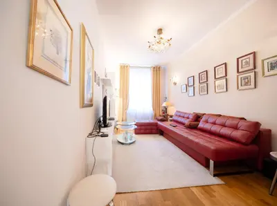 a living room with a red leather couch at One Bedroom city center Krakow in Kraków