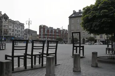 a group of chairs sitting in the middle of a street at Cracow Route #1 - Old Town in Kraków