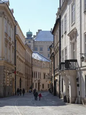 a group of people walking down a street with buildings at Cracow Route #2 - Old Town in Kraków