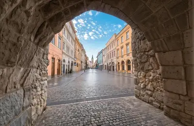 an archway in a city with a cobblestone street at Cracow Route #2 - Old Town in Kraków