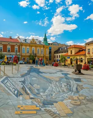 a mural in a square in a city with buildings at Cracow Vistula Boulevard #1 - Old Town in Kraków
