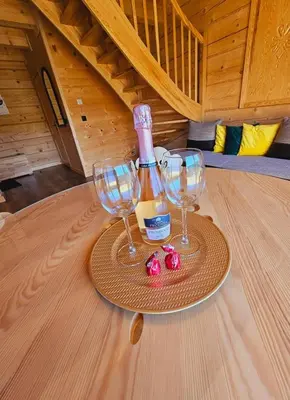a bottle of wine and two wine glasses on a table at Słoneczne Wzgórze- Odpoczywaj Pośród Natury in Łącko