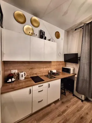 a kitchen with white cabinets and a wooden counter top at Cracow Vistula Boulevard #2 - Old Town in Kraków