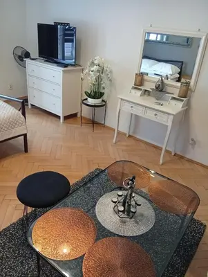 a living room with a table and a mirror at Pod Topola in Kraków