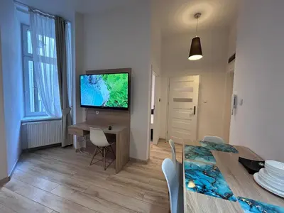 a living room with a dining room table and a television at Old Town Apt Bosacka Str - B10 in Kraków