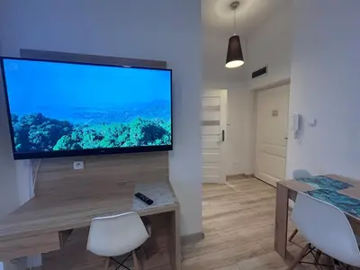 a living room with a large flat screen tv on a wall at Old Town Apt Bosacka Str - B10 in Kraków