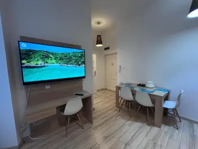 a living room with a table and a television on a wall at Old Town Apt Bosacka Str - B10 in Kraków