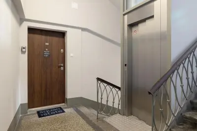 a hallway with a wooden door and stairs at AC - Sauna - 3 Bedroom Ap - Starowiślna 29 in Kraków