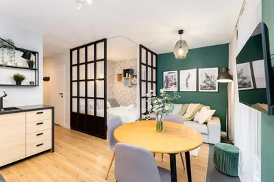 a living room with a table and a couch at Malila Premium Apartments Cracow Plac Bohaterów Getta in Kraków