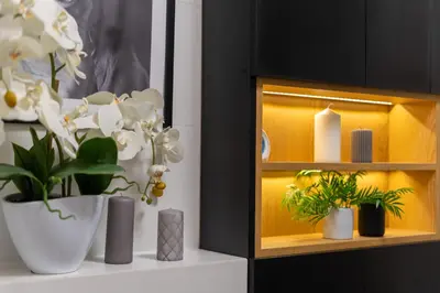 a shelf with flowers and plants on a table at Malila Premium Apartments Cracow Plac Bohaterów Getta in Kraków