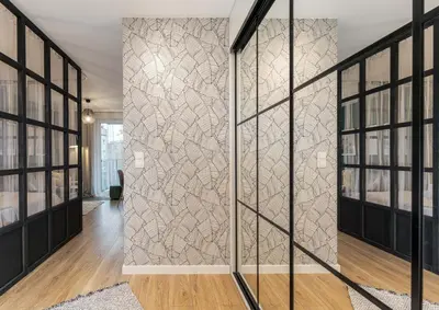a hallway with a wall of glass doors and a bedroom at Malila Premium Apartments Cracow Plac Bohaterów Getta in Kraków