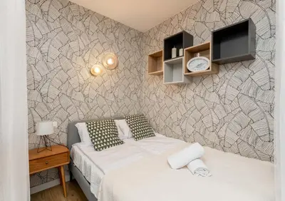 a bedroom with a bed and a tv on a wall at Malila Premium Apartments Cracow Plac Bohaterów Getta in Kraków
