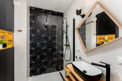 a bathroom with a black and white wall at Malila Premium Apartments Cracow Plac Bohaterów Getta in Kraków