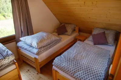 a small room with two beds and a window at Lawendowy Domek in Jaszczurowa