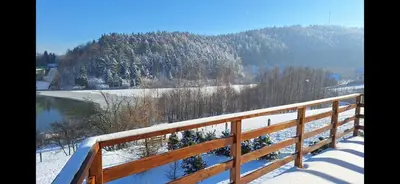 a wooden fence with snow on the ground at Lawendowy Domek in Jaszczurowa
