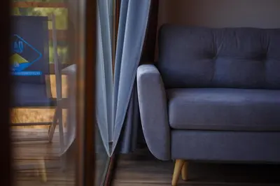 a blue chair sitting next to a window at Lawendowy Domek in Jaszczurowa