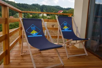 two blue chairs sitting on a deck with a view at Lawendowy Domek in Jaszczurowa