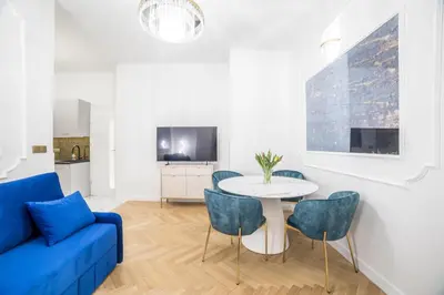 a living room with a blue couch and a table and chairs at Exclusive Panoramic APARTMENT in Kraków