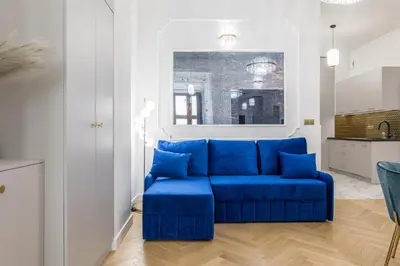 a blue couch in a white living room at Exclusive Panoramic APARTMENT in Kraków