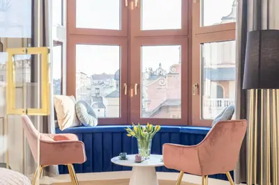 a room with two chairs and a table and windows at Exclusive Panoramic APARTMENT in Kraków