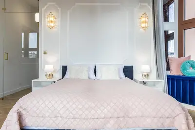 a bedroom with a large white bed with two lamps at Exclusive Panoramic APARTMENT in Kraków