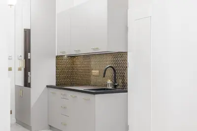 a kitchen with white cabinets and a sink at Exclusive Panoramic APARTMENT in Kraków