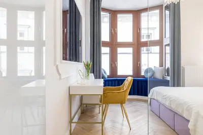 a bedroom with a desk and a bed and a bedroom with a tub at Exclusive Panoramic APARTMENT in Kraków