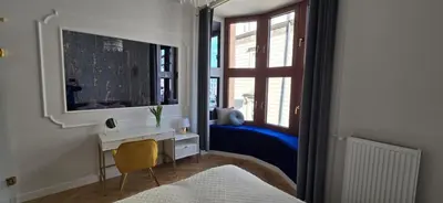 a bedroom with a mirror and a desk and a window at Exclusive Panoramic APARTMENT in Kraków