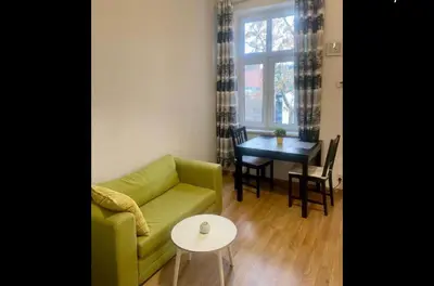 a living room with a green couch and a table at Sołtyka Apt in Kraków
