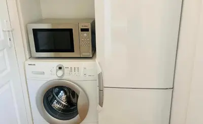 a microwave and a washing machine and a refrigerator at Sołtyka Apt in Kraków