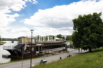 a boat on a river with a building on it at Wawel Castle across the street! Ozonated Apartment in Kraków