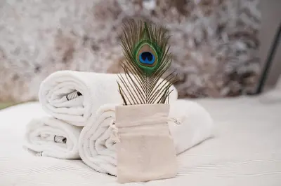 a towel and a peacock feather sitting on a bed at Wawel Castle across the street! Ozonated Apartment in Kraków