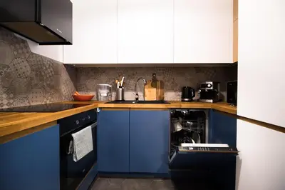 a kitchen with blue cabinets and a sink at Wawel Castle across the street! Ozonated Apartment in Kraków